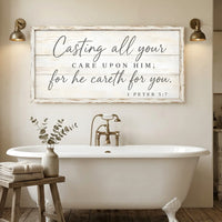 Bathroom with a freestanding bathtub, wooden stool with towels and plant, and a motivational quote sign on the wall. Casting All Your Care - 1 Peter 5:7
