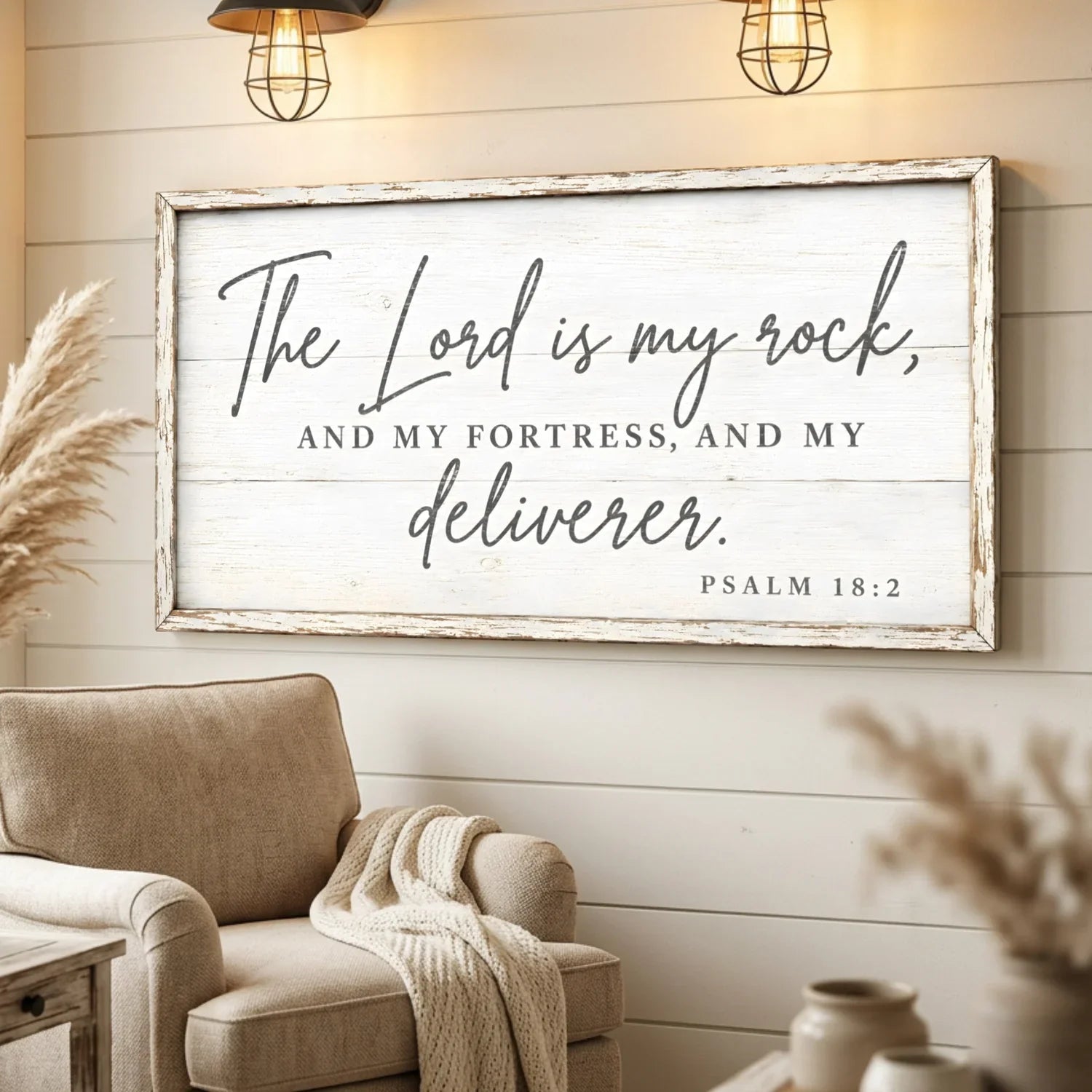 Framed biblical quote on a wall above a cozy armchair in a home setting.